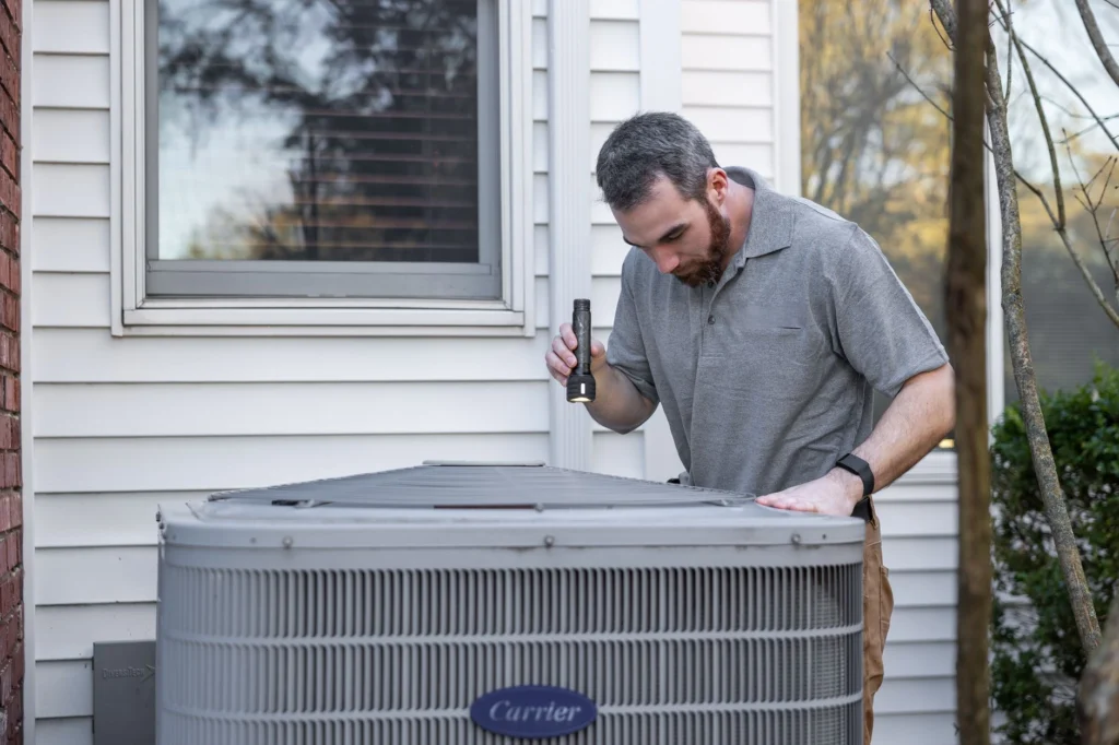 Technician inspecting an HVAC unit before duct cleaning